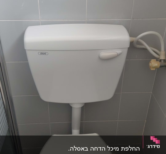 אסלה וניאגרה גלויה מותקנות ומחוברות לקיר בחדר שירותים